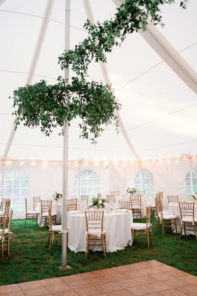 Circular hanging garden made with greenery, installed over brown tile dance floor for wedding.  