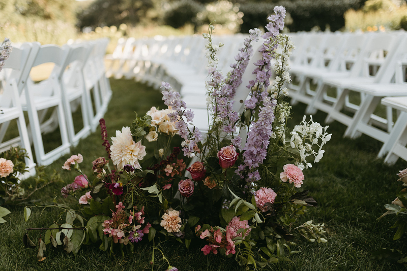 Aisle floral arrangement with bright summer florals and greenery.