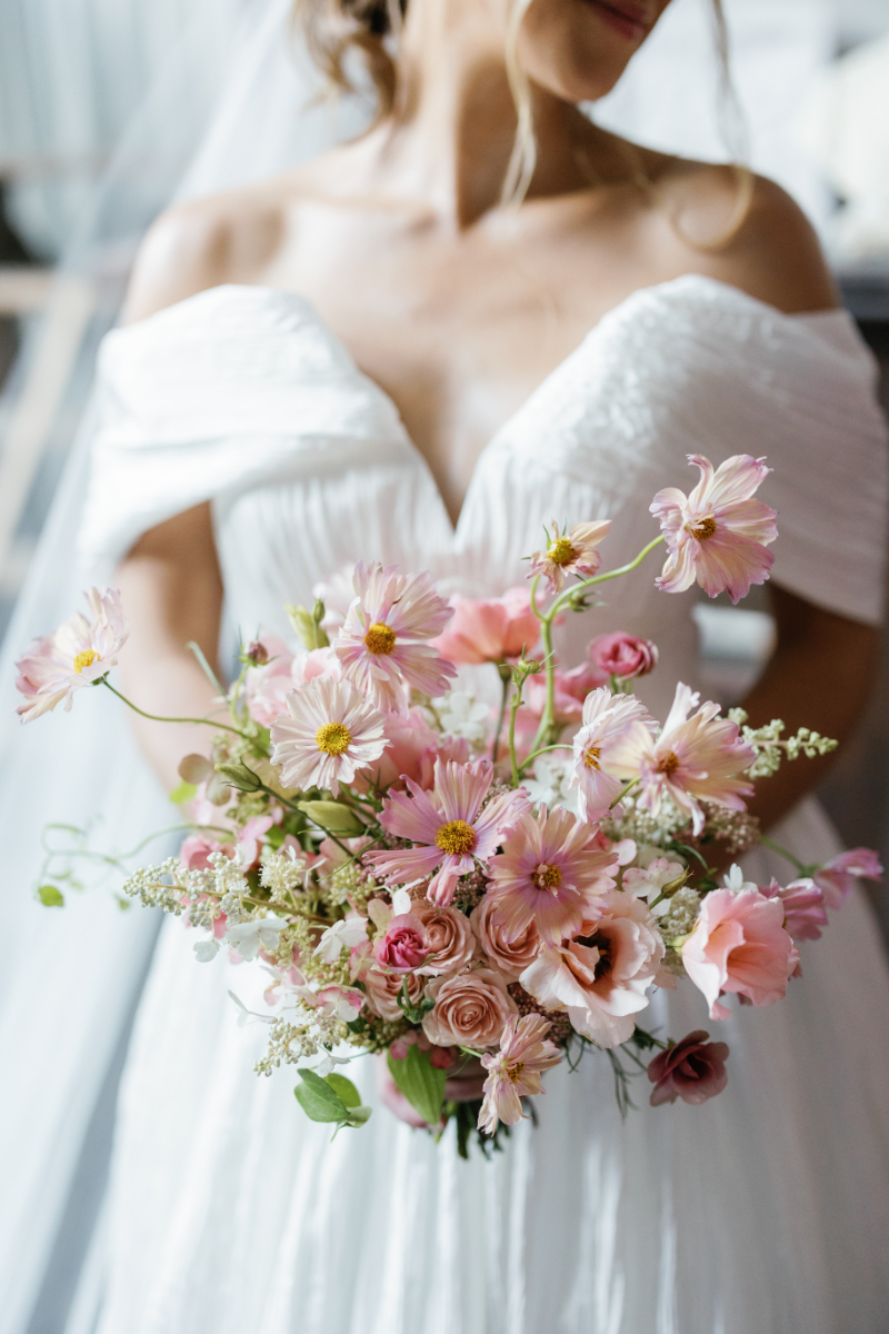 Bride holding pink monochromatic floral bouquet.