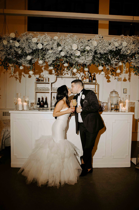 couple kissing at a flower themed wedding