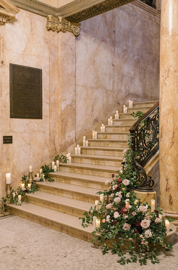 staircase featuring running floral arrangement and candles