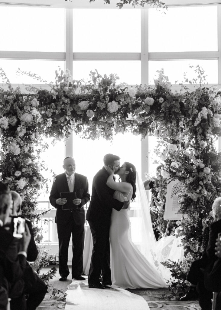 couple in black and white kissing under the chuppah at the Boston Harbor Hotel 