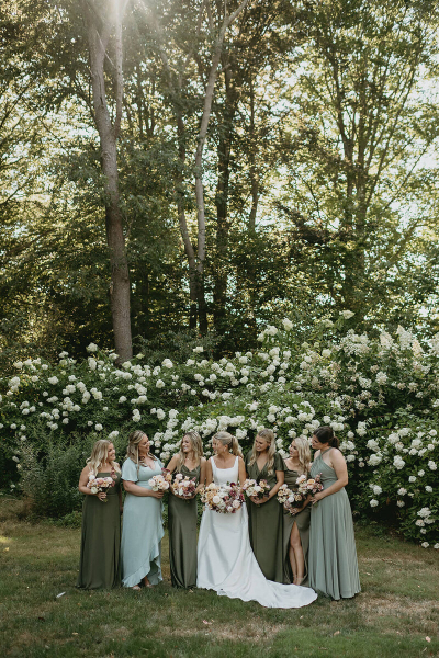 Bride standing with her bridesmaids in the garden