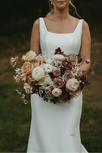 Bride standing alone with her elegant bouquet make of locally farmed florals 