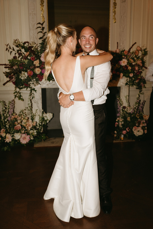 Bride and groom sharing their first dance in front of the floral fireplace at glen manor house  